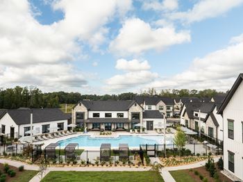 A large white building with a pool in front.